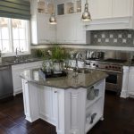 kitchen island ideas for small kitchens a white kitchen with olive-green tile backsplash and an ornate IRXEFXV
