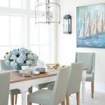 Large dining room windows invite lots of light shining on a white