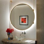 Install lighting behind the hanging mirror in your powder bathroom .