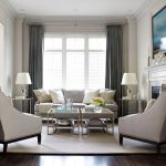 Elegant living room, with light grey sofa and arm chairs with .