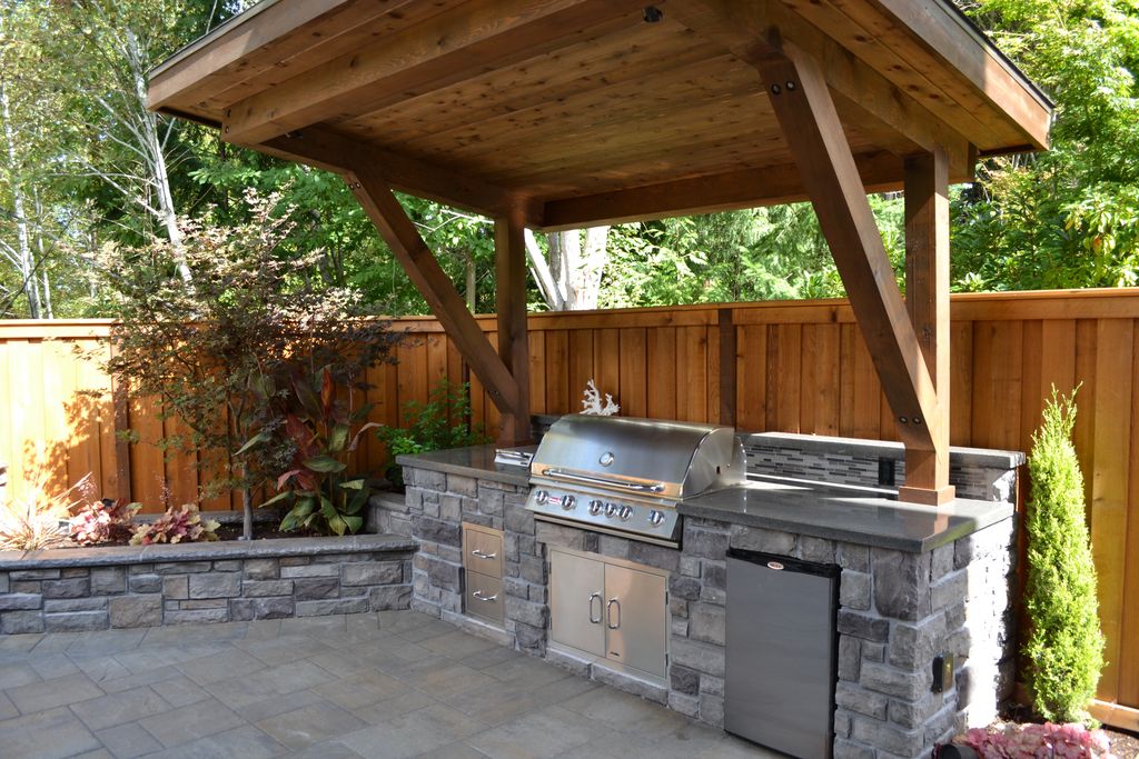 rustic patio with polished concrete, outdoor kitchen, raised beds, stacked  stone, fence UTDEMWZ