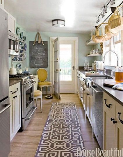 Galley kitchen with cream cabinets and blue wall @elise Anderson