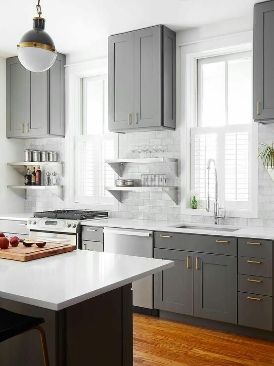 Gray kitchen cabinet color with white trim and white countertops .